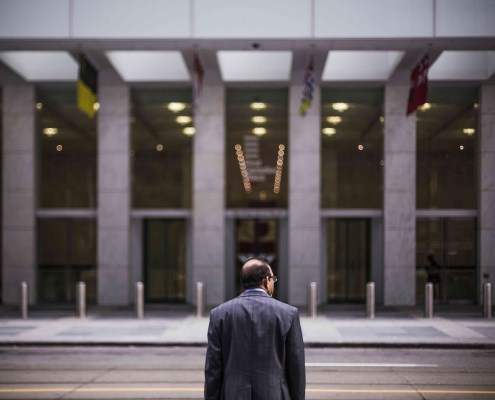 Un homme de dos et face à un bâtiment, prêt au changement.