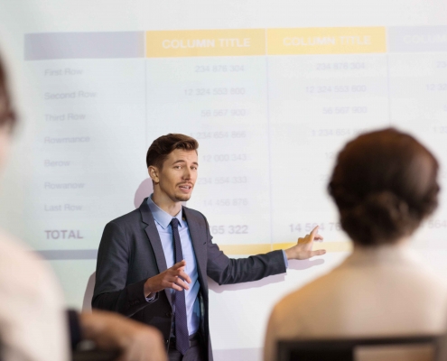 Un formateur dispensant sa formation avec un diaporama au tableau.