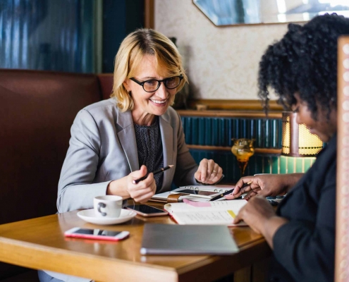 Deux femmes d'entreprise en train de travailler autour d'un café.